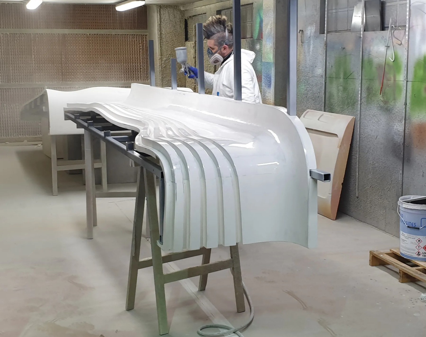 Sub-photo — Apprêt en cabine avant peinture. Plus la surface est tendue, plus les formes se lisent une fois éclairées.