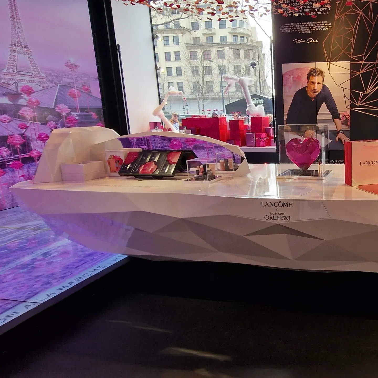 Sub-photo — Le comptoir au cœur de l’installation Lancôme. Décor de vitrine et sculptures reprennent le même vocabulaire de facettes.