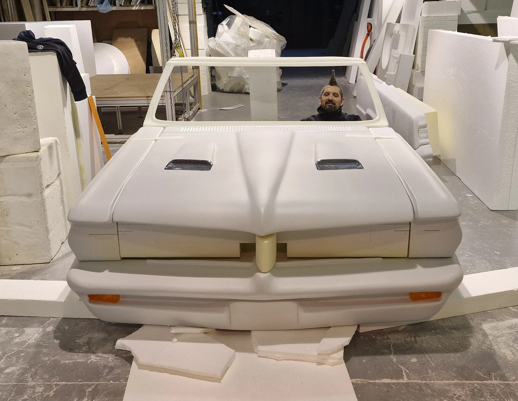 Sub-photo — Mastic et ponçage sur la face avant. Les clignotants sont de vraies pièces, encastrées dans la carrosserie.