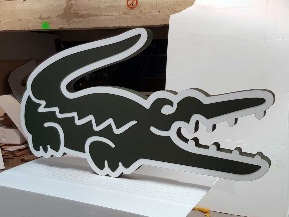 Découpe du logo Lacoste en polystyrène et PVC.